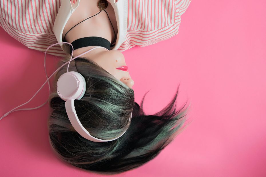 woman listening to music on pink background